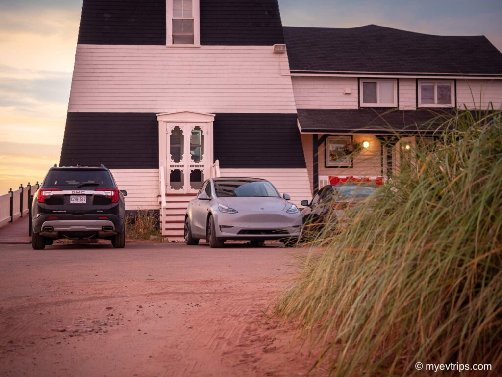 Tesla Model Y in front of West Point Lighthouse Inn at sunset