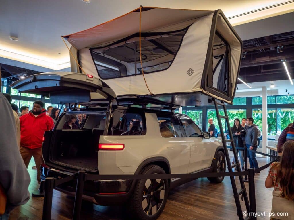 Rivian R2 on display with trunk open and tent on top
