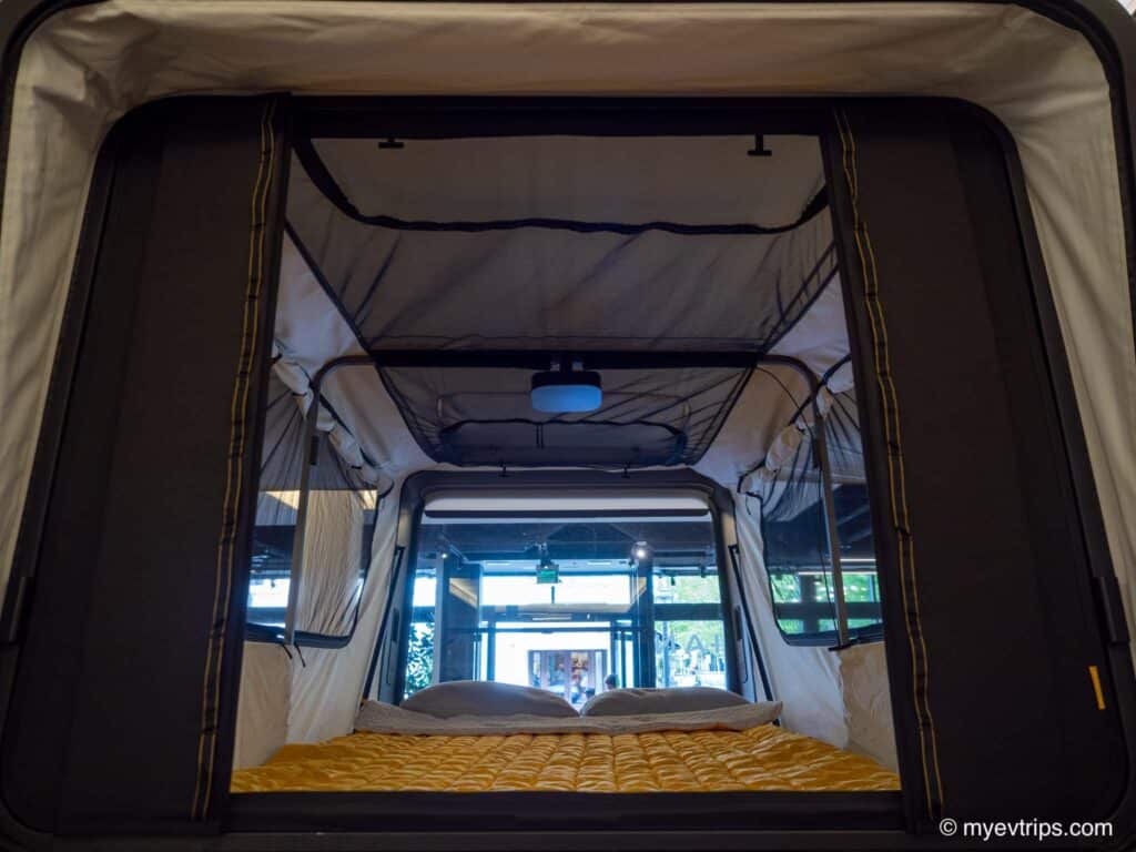 Inside the Rivian R2 display tent with projector on the roof