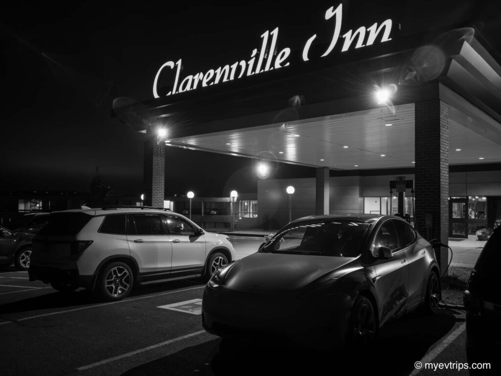 Black and white photo of a Tesla Model Y charging at the Clarenville Inn