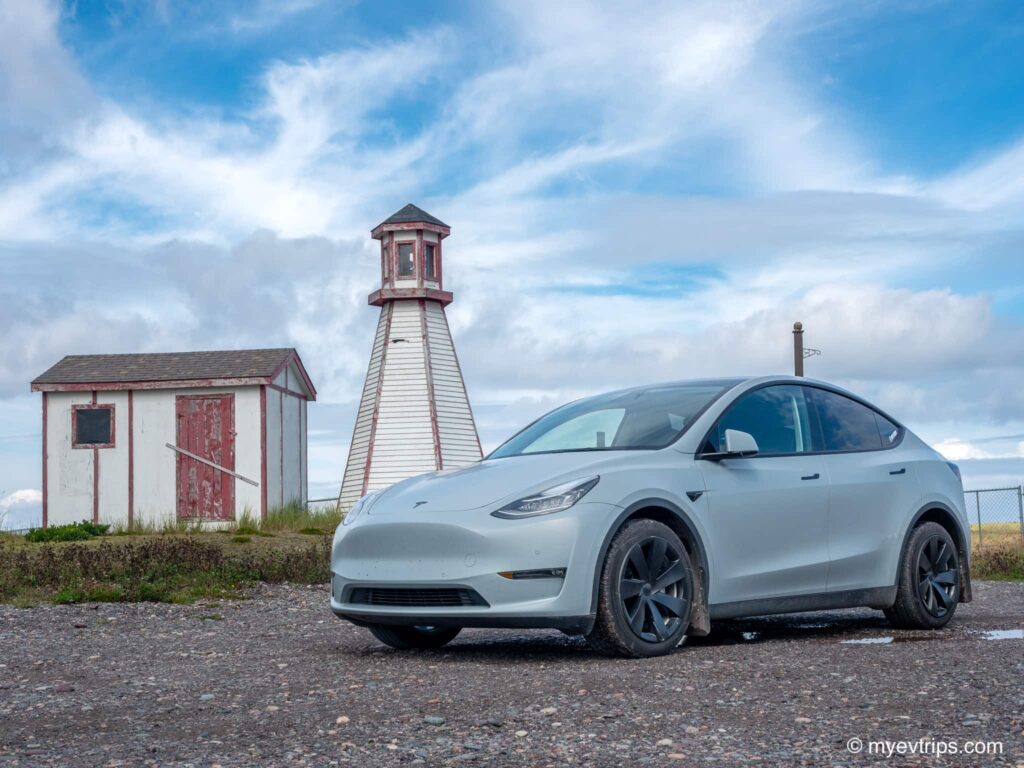 Lighthouse with Tesla Model Y in front on a Saint Pierre et Miquelon EV road trip