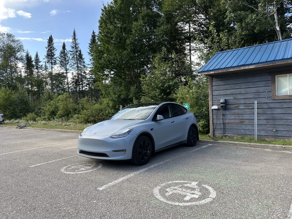 A Tesla Model Y charging at the Jacques-Cartier National Park on a Quebec City to Baie-Comeau road trip
