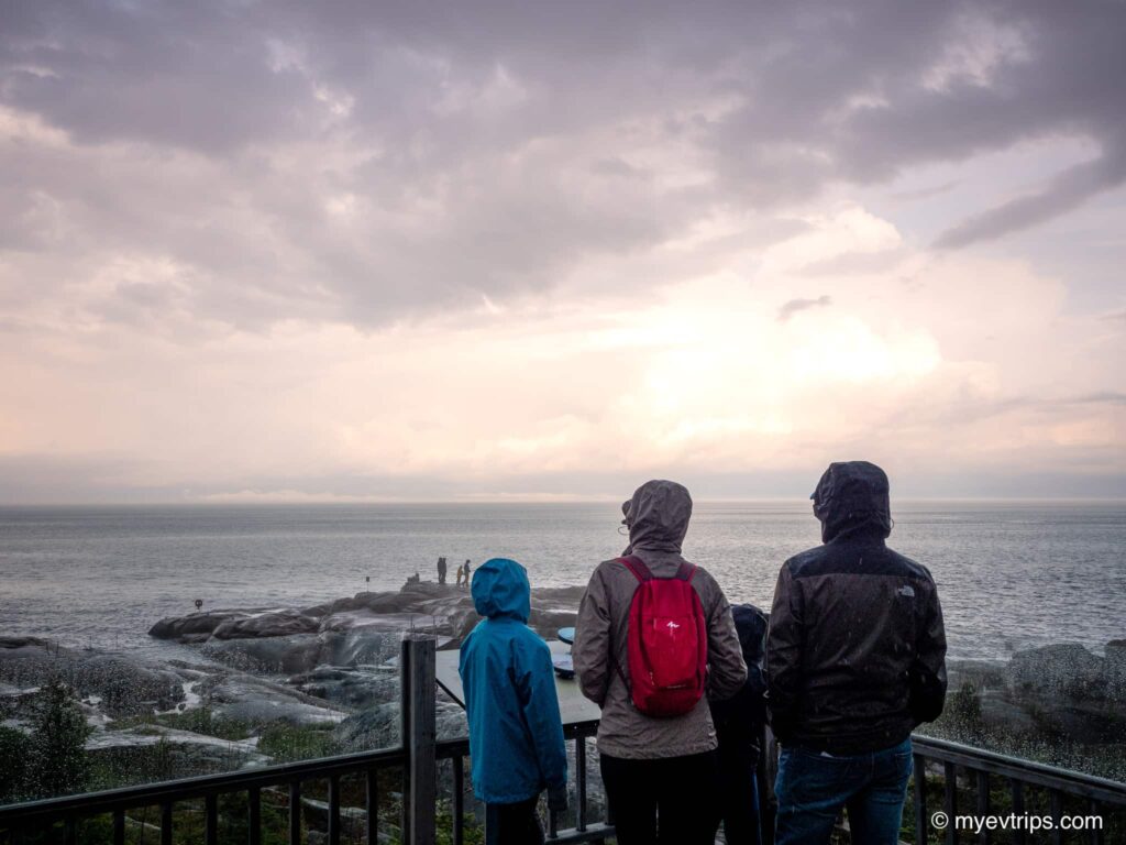 Family in rain jackets admiring view at Cap-de-Bon-Désir Interpretation and Observation Centre