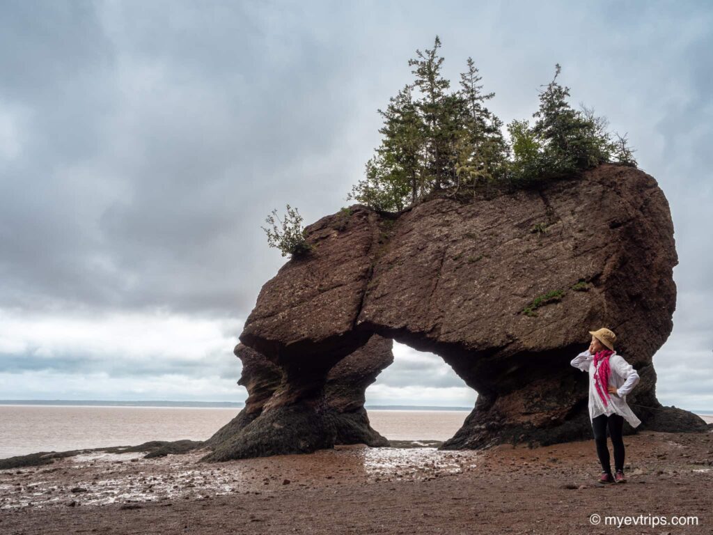 Women posing next to Hopewell Rocks at low tide in New Brunswick