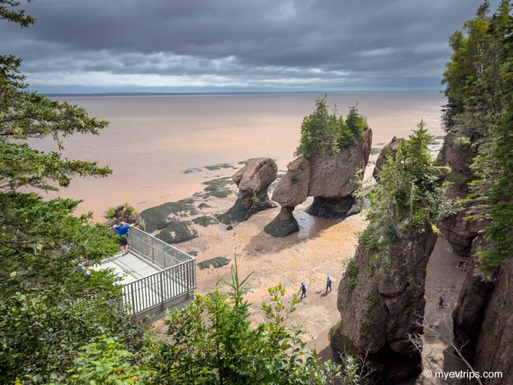 People standing next to Hopewell Rocks at low tide in New Brunswick