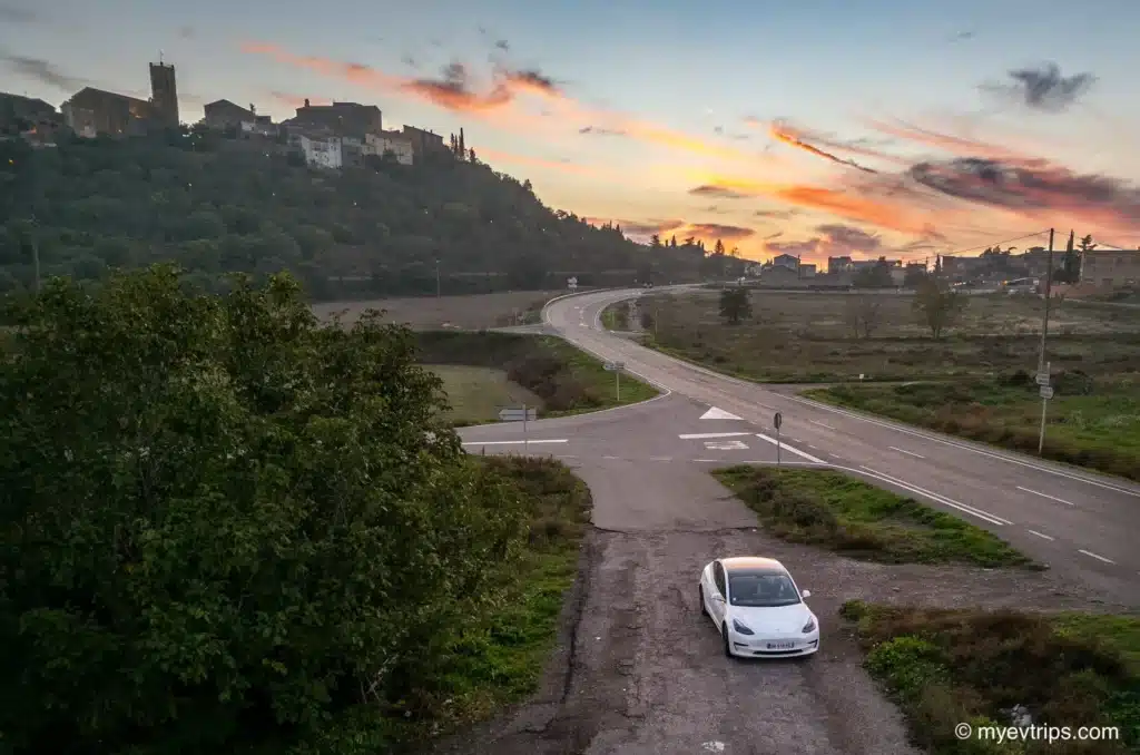 Tesla Model 3 at dusk in front of castle on an Andorra road trip