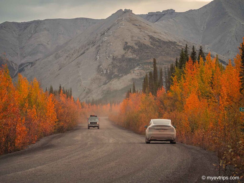 fall colours on the Dempster Highway with Model Y Tesla on the side of the road