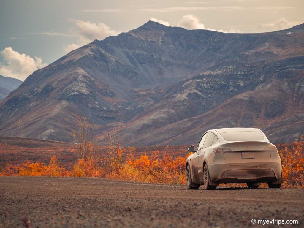fall colours on the Dempster Highway with Model Y Tesla on the side of the road